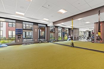 A gym with a yellow floor and various exercise equipment.